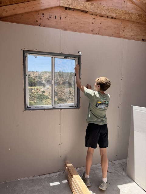 Reid installing a window on a Casas de Luz build